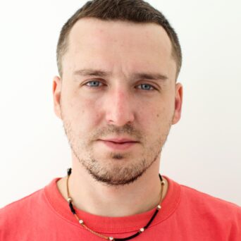 Man passport photo in red t-shirt with chain